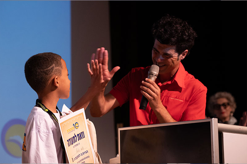 Tal Mosery high fives a child who receives a certificate