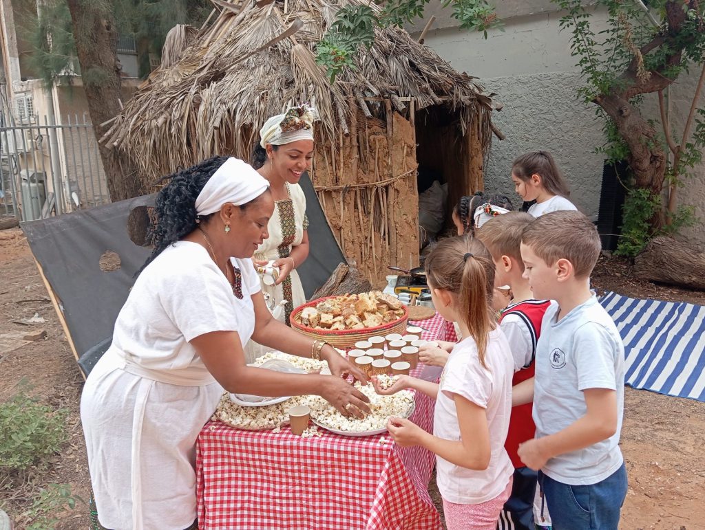 Ethiopian-Israeli parents handing out Sigd treats to students